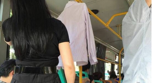 奇葩!武汉女子自带衣架上公交 在车厢内当众晒衣服
