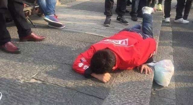 外卖小哥当街爬行为维权 工伤谁来管？