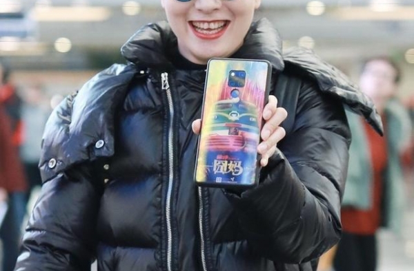 陶虹带女儿走机场，黑色棉服配阔腿裤简约大气，手机壳也能秀恩爱